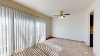 This single-floor residence at 11150 Somerset Dr in North Royalton, Ohio offers a well-organized layout with a bright, neutral aesthetic throughout. The living area is a standout space, featuring large sliding glass doors dressed with vertical blinds that allow natural light to cast across the plush carpeted floors. A ceiling fan with integrated lighting adds both function and a classic touch to the room.

The kitchen is notably updated, showcasing dark cabinetry paired with light granite-style countertops and light wood-tone flooring. It is equipped with stainless steel appliances, including a dishwasher and range, along with a stainless sink. A ceiling fan overhead adds airflow to the galley-style layout.

The bedrooms are carpeted and generously sized, with natural light provided by windows fitted with blinds. At least one bedroom includes a walk-in closet with a hanging rod for practical storage.

Two bathrooms serve the unit: one features a full tub-shower combination with white tile surround and wood-look tile flooring, while the second offers a glass-enclosed shower stall with matching dark cabinetry and wood-look flooring. Both bathrooms maintain a clean, cohesive design.
