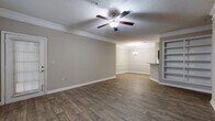 Located at 9200 Roberts Dr. in Sandy Springs, GA, this single-story residence offers a well-designed layout with a cohesive, neutral color palette throughout. The open living and dining area is highlighted by rich wood-look flooring, crown molding, and a ceiling fan with light fixture. A chandelier illuminates the dining space, which connects seamlessly to the living area through an open-concept flow. A built-in shelving unit adds functional character to the living room, while a private exterior door and large windows invite abundant natural light and views of surrounding greenery.

The galley-style kitchen is equipped with dark espresso cabinetry, light stone-look countertops, a tile backsplash, and stainless steel appliances including a range and dishwasher. A pass-through counter opening connects the kitchen to the main living area. Bedrooms feature plush carpeting, ceiling fans, and windows overlooking the wooded surroundings. The bathroom includes a full soaking tub with white tile surround, adding a clean, classic finish. Throughout the space, consistent trim work, textured ceilings, and warm tones create a comfortable and well-maintained living environment.