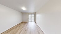 Located at 3350 Rosecrans Street in San Diego, CA, this single-floor unit offers an efficient and thoughtfully designed layout encompassing a dining room, kitchen, entrance, and bathroom. The main living and dining area is bright and airy, finished with light wood-tone laminate flooring that runs throughout. White walls and a textured ceiling amplify the sense of openness, while a sliding glass door fitted with vertical blinds allows natural light to pour in and provides direct access to an outdoor area. The compact kitchen is smartly configured with light gray cabinetry, white quartz-style countertops, a built-in cooktop, and an over-the-range microwave. A pass-through shelf connects the kitchen to the adjacent space, enhancing the open feel. The entrance area features a vanity with a sink, soft-toned cabinetry, a round decorative mirror, and a mirrored sliding-door closet with built-in shelving and hanging rods — offering practical storage. The clean, white bathroom includes a combination tub and shower with a handheld showerhead and tile flooring. The overall aesthetic is modern and neutral, creating a versatile, move-in-ready environment ideal for those seeking a streamlined lifestyle in San Diego.