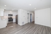 Located at 1704 Hornblend St in San Diego's Pacific Beach neighborhood, this 2-bedroom, 2-bathroom unit offers a clean, modern design throughout its well-utilized single-floor layout. Light wood-style flooring flows consistently through every room, complementing the crisp white walls and creating a bright, cohesive aesthetic.

The kitchen is a standout feature, outfitted with white shaker cabinetry, light quartz countertops, a stainless steel sink, and a full suite of stainless steel appliances including a refrigerator, range, microwave, and dishwasher. Recessed lighting adds a polished finish to this functional space.

The combined dining and living area provides an open, comfortable gathering space with recessed lighting. Both bedrooms are well-proportioned and filled with natural light; the primary bedroom includes sliding glass door access to a private balcony, while the second bedroom features a window with vertical blinds and a built-in closet with sliding doors.

The two bathrooms reflect the unit's modern sensibility: one features a sleek frameless glass walk-in shower with subway tile surround, while the second offers a full shower-tub combo. Both include white vanities and wood-style flooring. Additional conveniences include in-unit laundry, a utility room, and ample closet storage throughout.