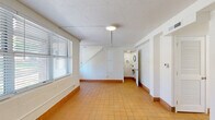 Located at 1100 E Washington Ave in East Point, GA, this two-story home offers five bedrooms and two bathrooms across two floors. The ground floor features warm terra cotta tile flooring throughout its open hallway, kitchen, and bathroom areas. The renovated kitchen is outfitted with white shaker cabinetry, light quartz countertops, a matte black faucet, and stainless steel appliances including a range, microwave, and dishwasher. A full bathroom on this level features painted concrete block walls and terra cotta tile, with a compact, functional layout tucked beneath the staircase. The staircase connects to the upper floor, which houses the majority of the bedrooms. Bedrooms feature light wood-look flooring, painted concrete block walls, and windows fitted with horizontal blinds that allow natural light throughout. Ceiling fans are present in select bedrooms. The primary bedroom connects directly to a fully updated en-suite bathroom showcasing large-format grey tile flooring, a glass-enclosed walk-in shower with white subway tile and matte black fixtures, and a white vanity with quartz countertop. Closet space includes wire shelving for practical storage. The consistent white-painted walls and clean finishes give the home a bright, cohesive aesthetic throughout.