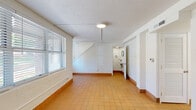 Located at 1100 E Washington Ave in East Point, GA, this two-story home offers five bedrooms and two bathrooms across two floors. The ground floor features warm terra cotta tile flooring throughout its open hallway, kitchen, and bathroom areas. The renovated kitchen is outfitted with white shaker cabinetry, light quartz countertops, a matte black faucet, and stainless steel appliances including a range, microwave, and dishwasher. A full bathroom on this level features painted concrete block walls and terra cotta tile, with a compact, functional layout tucked beneath the staircase. The staircase connects to the upper floor, which houses the majority of the bedrooms. Bedrooms feature light wood-look flooring, painted concrete block walls, and windows fitted with horizontal blinds that allow natural light throughout. Ceiling fans are present in select bedrooms. The primary bedroom connects directly to a fully updated en-suite bathroom showcasing large-format grey tile flooring, a glass-enclosed walk-in shower with white subway tile and matte black fixtures, and a white vanity with quartz countertop. Closet space includes wire shelving for practical storage. The consistent white-painted walls and clean finishes give the home a bright, cohesive aesthetic throughout.