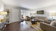 Located at 2530 Yorktown St in Houston's desirable Galleria/Uptown area, this single-floor residence offers a well-appointed layout designed for comfortable everyday living. The living room serves as the heart of the home, featuring rich dark hardwood flooring, crown molding, and a large window that draws in natural light. The open, welcoming atmosphere is complemented by neutral gray walls that provide a clean, modern backdrop throughout.

Adjacent to the living area, a dedicated dining space is defined by classic wainscoting detail and louvered closet doors, adding architectural character to the room. The galley-style kitchen is efficiently designed with white cabinetry, granite countertops, a stainless steel sink, and black appliances, offering a functional and stylish cooking environment.

The bedroom is a calm retreat featuring plush carpeting, a ceiling fan, generous closet storage with louvered doors, and windows dressed with patterned drapes that allow for natural light control. The full bathroom includes a granite-topped vanity with white cabinetry and a tub-shower combination, maintaining the home's consistent attention to detail. Throughout the space, crown molding and cohesive finishes tie each room together in a polished, unified aesthetic.