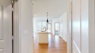 This well-designed 2-bedroom, 2-bathroom residence offers a thoughtful single-floor layout that balances comfort and modern style. The open-concept living and kitchen area serves as the heart of the home, anchored by a sleek kitchen island with an integrated sink and striking dual pendant lights in matte black. White shaker cabinets, a subway tile backsplash, stainless steel appliances, and light hardwood-style flooring give the kitchen a clean, contemporary feel. The living area flows naturally from the kitchen, bathed in natural light from multiple windows that frame outdoor views.

Both bedrooms feature plush carpeting, ceiling fans, and natural light through window blinds. Each bedroom is paired with its own closet — including a walk-in closet with built-in shelving and hanging rods, providing generous storage. The primary bedroom is a spacious retreat with large windows and direct access to its dedicated bathroom.

The two bathrooms are finished with white cabinetry, light countertops, black hardware accents, and hardwood-style flooring. One bathroom features a tub-shower combination adorned with large-format marble-look tile and black fixtures. A connecting hallway ties all rooms together, completing this cohesive and move-in-ready layout.