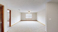 Located at Country Village Drive in Smyrna, Tennessee, this one-bedroom, one-bathroom residence offers a practical and comfortable single-floor layout. The kitchen is a standout feature, boasting an abundance of white cabinetry with warm wood trim that stretches from counter to ceiling, providing generous storage. It includes a full suite of appliances — refrigerator, electric range, dishwasher, and a sink — all set above durable wood-look vinyl flooring that extends into the adjacent living area. The spacious bedroom is finished with plush wall-to-wall carpeting, neutral-toned walls, and rich wood baseboard trim. Natural light enters through windows fitted with blinds, offering pleasant outdoor views. The textured ceiling and flush-mount light fixture complete the room's clean, understated aesthetic. The bathroom features the same wood-look flooring, a vanity with a white countertop and mirror, and a shower/tub combination. A dedicated laundry area and a walk-in closet with wire shelving overhead add practical storage and utility. Throughout the home, consistent neutral tones, wood trim accents, and textured ceilings create a cohesive and move-in-ready atmosphere well-suited for comfortable everyday living.
