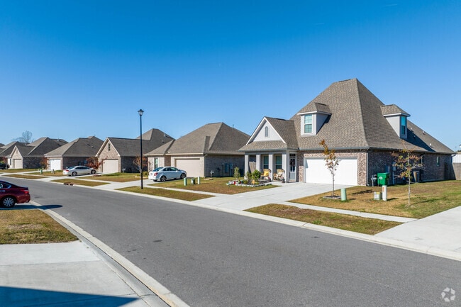 A row of brick homes adorns a quiet road in Prairieville.