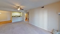 This single-floor residence at 2 Retreat offers a thoughtfully designed layout that balances comfort and functionality. The spacious living area is finished with plush carpeting and features a ceiling fan with light fixture, creating a comfortable, well-ventilated environment. A pass-through opening connects the living space to the kitchen, enhancing the open feel of the home.

The galley-style kitchen is efficiently designed with ample white cabinetry, dark granite-style countertops, a double-basin sink, and white appliances including a range, microwave, and refrigerator. Adjacent to the kitchen, a dedicated dining area features warm hardwood-style flooring and a pendant light overhead, providing an inviting space for meals.

The bedrooms are carpeted and naturally lit through windows with exterior views, offering a calm retreat. Each room includes generous closet space, with at least one bedroom featuring a walk-in closet with built-in shelving and hanging rods.

Two full bathrooms serve the residence, each with a tub-shower combination, hardwood-style flooring, and neutral finishes. One bathroom includes a vanity with a large mirror and well-placed lighting. Throughout the home, neutral wall tones and clean trim work create a cohesive, move-in-ready aesthetic.
