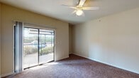 Located at 4100 Vista Ln in Kaufman, Texas, this single-floor residence offers a well-organized layout designed for comfortable everyday living. The spacious living area is finished with plush carpeting and features a ceiling fan with integrated lighting, creating a bright and airy atmosphere. A sliding glass door floods the room with natural light and provides direct access to an outdoor balcony area with views of the surrounding greenery.

The kitchen is equipped with a breakfast bar-style pass-through counter, warm wood-toned cabinetry, and black appliances including a range and built-in microwave, with tile flooring that complements the carpeted living spaces.

The bedrooms are generously sized and carpeted, each with ample natural light. One bedroom features mirrored sliding closet doors, while another includes a standard closet with shelving. A ceiling fan is present in the primary bedroom area.

Two full bathrooms serve the residence, each featuring a tiled tub-and-shower combination. One bathroom includes a vanity with dark countertop, white cabinetry, a large wall mirror with overhead lighting, and tile flooring, offering a clean and functional design throughout.