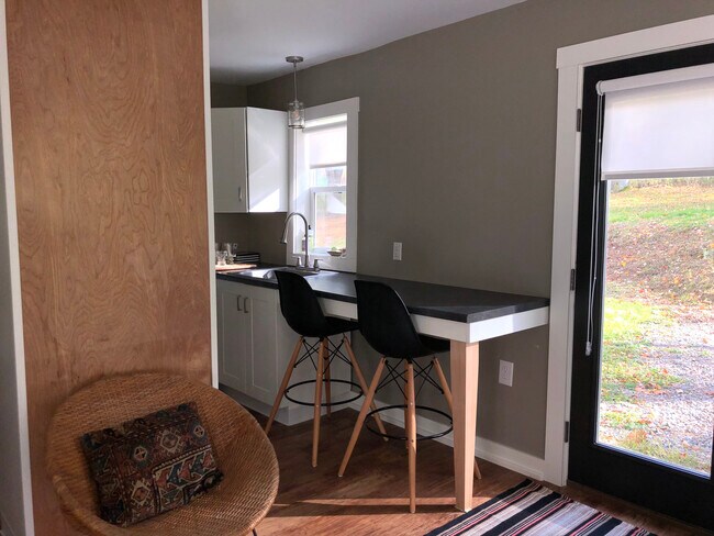 Zona de trabajo o comedor con taburetes de bar. - 1635 Ellis Hollow Rd