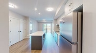 This thoughtfully designed 2-bedroom, 2-bathroom unit at 1100 Afton Drive in Windsor, Ontario offers a clean, modern aesthetic throughout. The open-concept kitchen serves as the heart of the home, featuring white shaker-style cabinetry, a white subway tile backsplash, quartz countertops, stainless steel appliances, and a central island — ideal for both cooking and entertaining. Light wood-tone flooring runs consistently throughout the space, enhancing the bright, airy atmosphere.

Both bedrooms are well-proportioned and bathed in natural light through large windows that frame outdoor views of the surrounding neighbourhood and greenery. The primary bedroom offers a comfortable retreat with its own dedicated closet. A second closet provides additional storage elsewhere in the unit.

The two bathrooms are finished with white cabinetry, quartz countertops, and wood-look flooring. One bathroom features a full tub-shower combination, while the second is equipped with accessible grab bars for added convenience.

A private balcony extends the living space outdoors, offering open views of the surrounding area under open skies — a pleasant spot to enjoy fresh air. The unit's neutral palette, recessed and flush-mount lighting, and consistent finishes throughout create a cohesive and welcoming living environment.