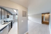 Located at 211 Hawthorne Ave in Central Islip, NY, this well-appointed 2-bedroom, 1-bathroom unit offers a thoughtfully designed single-floor layout. Light wood-style flooring runs throughout, complementing a neutral gray color palette that gives the space a clean, modern feel.

The kitchen and dining area form a combined, functional hub at the heart of the unit. The kitchen is outfitted with dark gray shaker-style cabinetry, a marble-look tile backsplash, white quartz countertops, stainless steel appliances including a gas range and built-in microwave, and a central island that provides additional prep and dining space. A ceiling fan adds comfort to this area, which also benefits from natural light through a window.

The spacious living room flows naturally from the kitchen, offering generous open floor space. The generously sized primary bedroom provides ample room and includes closet access. The second bedroom features a window with outdoor views and a wall-mounted AC unit alongside baseboard heating. Three closets throughout the unit offer plentiful storage.

The bathroom is clean and contemporary, featuring a tiled tub-and-shower combo, a gray vanity with a white basin, brushed nickel fixtures, and a window for natural light. A private outdoor balcony overlooks the landscaped community grounds, parking area, and surrounding greenery.