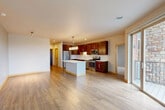 Located at 8430 Market St in Middleton, WI, this well-appointed 3-bedroom, 2-bathroom residence offers a thoughtfully designed single-level layout with generous living space throughout. The open-concept kitchen and living area serves as the heart of the home, featuring rich dark wood cabinetry, stainless steel appliances including a gas range, microwave, and refrigerator, and a large central island with a crisp white countertop. Pendant lighting and hardwood-style flooring enhance the warm, modern aesthetic, while large windows flood the space with natural light and offer views of the surrounding Middleton neighborhood.

The three bedrooms are carpeted for comfort, each equipped with ceiling fans or ample lighting and generous closet space — the home boasts seven closets in total, providing exceptional storage. The primary bedroom includes access to a private bathroom with rich wood vanity cabinetry and white countertops. Two patios offer outdoor living space with open views of the cityscape and seasonal foliage.

Additional highlights include a dedicated in-unit laundry room with full-size washer and dryer, a separate hallway, and frosted glass interior doors that add a contemporary touch. The overall ambiance is clean, modern, and move-in ready.