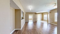 Located at 5009 Park Central Dr in Orlando, FL, this single-floor, 3-bedroom, 1-bathroom residence offers a well-organized and functional layout across a generously sized floor plan. The open living area greets you upon entry, showcasing warm wood-look flooring, neutral tan walls, and a textured ceiling that adds subtle character. Large windows and a sliding glass door fill the space with abundant natural light while offering outdoor views of surrounding greenery.

The kitchen features white cabinetry, dark granite-style countertops, and a full suite of appliances including a stainless refrigerator, electric range, and dishwasher. A pass-through opening connects the kitchen to the main living area, enhancing the open feel. A closeted pantry provides additional storage.

The spacious primary bedroom includes a ceiling fan, a large window, and access to a walk-in closet outfitted with wire shelving. The additional bedrooms are carpeted and feature ceiling fans and ample natural light through wide windows. The full bathroom is clean and bright, offering a tub-shower combination, a white vanity with dark countertop, and a window for ventilation. Plush carpet and hardwood-look flooring are used throughout to define each area of this comfortable, move-in-ready Orlando residence.