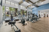 Live your best life at 4700 Riverwood Cir, Raleigh, NC. This expansive 1,790 sq ft fitness center is designed for those who refuse to compromise on wellness. Soaring ceilings with striking dark wood beam accents, floor-to-ceiling windows, and elegant herringbone wood-look flooring create an energizing yet refined atmosphere. Natural light floods the cardio zone, lined with treadmills, ellipticals, and bikes overlooking lush greenery. A dedicated functional training studio with mirrored walls and a full complement of free weights empowers every workout. This is more than a gym — it's a lifestyle destination.