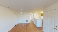 Located on Cliffview Drive in Indianapolis, Indiana, this single-floor unit offers a practical and comfortable layout designed for everyday living. The open living area features warm wood-look laminate flooring and is illuminated by track lighting, creating a bright and welcoming atmosphere. A built-in closet with sliding doors provides convenient storage directly off the main living space.

The kitchen is thoughtfully designed with ample oak cabinetry, generous counter space, a double-basin sink, and a full suite of appliances including a refrigerator and electric range. A peninsula counter separates the kitchen from the living area, offering both workspace and a casual dining option.

The bedrooms are carpeted for comfort and benefit from natural light through windows overlooking the surrounding landscape. One bedroom features a sliding glass door that opens to an outdoor area with scenic views, while another includes access to a walk-in closet. Additional storage is provided throughout.

The bathrooms are clean and functional, each featuring a vanity with storage drawers, a large mirror with overhead lighting, and hardwood-style flooring. Textured ceilings are consistent throughout the unit, adding a classic residential character. The overall design is clean, neutral, and move-in ready, making it a versatile space suited to a variety of lifestyles.