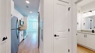 Located at 1405 14th St W in Bradenton, Florida, this efficiently designed one-bedroom, one-bathroom unit offers a clean, modern aesthetic throughout its single-floor layout. Light wood-style flooring flows through the main living areas, complemented by crisp white walls and recessed lighting that create a bright, airy atmosphere.

The kitchen is a standout feature, outfitted with white shaker-style cabinetry, granite countertops, a classic white subway tile backsplash, and a full suite of stainless steel appliances including a refrigerator, electric range, over-the-range microwave, and dishwasher. Matte black hardware and fixtures add a contemporary contrast throughout.

The living area is open and well-lit, with easy access to the kitchen. The bedroom offers a comfortable footprint, bathed in natural light from multiple windows fitted with blinds, providing both brightness and privacy.

The bathroom continues the modern design language, featuring a granite-topped vanity with matte black fixtures, a tiled tub-shower combination with vertical tile detailing, and warm wood-style flooring. A dedicated closet provides convenient storage. The unit also includes a hallway connecting all rooms, with panel-style interior doors accented in matte black hardware for a cohesive, polished look.
