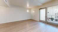 Located at 521 W Colorado St in Glendale, CA, this single-floor, one-bedroom, one-bathroom unit offers a thoughtfully designed modern interior. The open-plan kitchen and living area serves as the heart of the space, finished with light wood-look flooring that enhances the bright, clean aesthetic throughout. The kitchen is well-appointed with dark espresso cabinetry, stainless steel appliances including a refrigerator, range, and microwave, a dishwasher, and light countertops. A skylight positioned above the kitchen floods the area with natural light, complementing the airy white walls. The living area extends comfortably from the kitchen, with a glass sliding door providing access to the exterior and additional natural light. The bedroom features plush carpeting, a window with vertical blinds, and two closets offering generous storage. The bathroom is finished with large-format light tile flooring, a soaking tub with shower, and a clean, minimalist design. A dedicated laundry area adds everyday convenience. The overall ambiance is contemporary and functional, with a neutral palette throughout.
