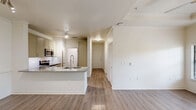Located at 6515 Deseo in Irving, TX, this single-floor, 2-bedroom, 2-bathroom residence offers a thoughtfully designed layout with modern finishes throughout. Wood-style flooring flows seamlessly across the entire unit, complementing the bright, neutral color palette.

The kitchen serves as a central focal point, featuring granite countertops, a large peninsula with an undermount sink, stainless steel appliances including a gas range, microwave, refrigerator, and dishwasher, along with soft-toned shaker-style cabinetry and a clean white tile backsplash. A pantry provides additional storage convenience.

The hallway connects the main living areas to both bedrooms, each equipped with ceiling fans and windows that invite natural light and outdoor views. The primary bedroom includes access to its own bathroom and multiple closets, including a spacious walk-in closet with wire shelving systems. The second bedroom also benefits from generous closet space.

Both bathrooms feature granite-topped vanities and wood-style flooring. The guest bath includes a full tub-shower combination with tiled surround. A dedicated laundry room houses a full-size washer and dryer. Completing the unit is a private balcony, a utility room, and crown molding details that add a refined touch throughout.