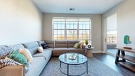 Located at 644 Chlois Ln in Columbus, Ohio, this single-floor residence offers a thoughtfully designed open-concept layout that seamlessly connects the main living areas. The kitchen is outfitted with warm-toned wood cabinetry, stainless steel appliances including a range, microwave, refrigerator, and dishwasher, complemented by white countertops and a textured tile backsplash. Wood-style plank flooring runs throughout the kitchen and living areas, adding warmth and visual continuity to the space.

The living room is a standout feature, highlighted by an expansive multi-panel window that floods the room with natural light and offers open outdoor views. Dark hardwood-style flooring anchors the space, which is large enough to accommodate a generous sectional sofa alongside additional seating and entertainment furnishings.

The bedroom is carpeted for comfort and features large windows that continue the theme of abundant natural light and outdoor views. The bathroom includes wood-toned cabinetry with a white countertop and direct access to a walk-in closet with wire shelving, providing practical storage solutions. Neutral wall tones and clean finishes throughout lend the space a cohesive, contemporary aesthetic.