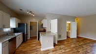 Located at 2425 Summerlin Ridge Rd in Winston-Salem, NC, this two-floor home offers a well-designed layout with functional living spaces throughout. The kitchen serves as a central highlight, featuring white cabinetry, granite countertops, a central island, and stainless steel appliances including a refrigerator, microwave, gas range, and dishwasher. Warm hardwood-style flooring runs through the kitchen and main living areas, adding a cohesive and inviting aesthetic.

The bedrooms are carpeted for comfort and include ceiling fans with lighting, windows that invite natural light and outdoor views, and generous closet space with wire shelving systems for organized storage. The neutral, warm-toned walls throughout the home provide a versatile backdrop.

The bathrooms are finished with hardwood-style flooring, white vanities with solid countertops, and tub-shower combinations with chrome fixtures. One bathroom features a window, enhancing ventilation and natural light. The clean, understated design of each bathroom contributes to the home's overall polished appearance.

Textured ceilings are present in several rooms, and the two-floor layout provides a clear functional separation between living and private spaces. Overall, this home presents a clean, move-in-ready environment with consistent finishes throughout.