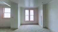 This two-floor space presents a clean, move-in-ready environment defined by a neutral color palette and thoughtful design details throughout. The interior is finished with soft, wall-to-wall carpeting that adds warmth and comfort underfoot, while smooth white walls and ceilings create a bright, airy atmosphere. Natural light is a key feature, with double-hung windows framed in light wood that invite daylight deep into the rooms and provide views of the surrounding greenery. A wall-mounted heating unit ensures year-round comfort, and recessed lighting in the ceiling adds a subtle, modern touch. The generous ceiling height enhances the overall sense of openness and volume within each room. The layout spans two floors, offering well-defined spaces that provide both functionality and flexibility. Throughout the property, the consistent use of light tones and clean finishes contributes to a cohesive, tranquil ambiance. This space serves as an ideal blank canvas, ready to be personalized while already offering a polished and comfortable foundation.