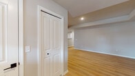 This single-floor residence offers a thoughtfully designed layout that balances functionality and modern style throughout its living spaces. The kitchen is a standout feature, showcasing white cabinetry accented with gold hardware, dark granite countertops, a classic subway tile backsplash, and a full suite of stainless steel appliances including a range, microwave, and refrigerator. A breakfast bar provides additional counter space and opens the kitchen toward the adjacent living and dining areas.

The open living and dining area is finished with warm-toned hardwood-style flooring that flows throughout the main living spaces, complemented by recessed lighting and stylish pendant fixtures that add a contemporary touch. Neutral-toned walls throughout create a clean, inviting atmosphere.

The bedroom features plush carpeting, a window that invites natural light, and a dedicated closet with built-in shelving and hanging rods. Two bathrooms serve the residence: one includes a full tub-and-shower combination, while the other is appointed with a glass-enclosed walk-in shower, a vanity with dark granite countertops and gold-accented hardware, and tile flooring. An entry hallway with a paneled door provides a welcoming transition into the home. The overall design reflects a clean, updated aesthetic throughout.