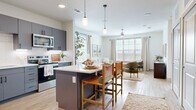 Located in Dripping Springs, TX, this thoughtfully designed one-bedroom, one-bathroom residence offers a well-appointed single-floor layout that maximizes both function and comfort. Light wood-tone flooring flows throughout, complemented by crisp white walls that create a bright, airy ambiance.

The open-concept kitchen and living area serves as the heart of the home. The kitchen features slate-gray cabinetry with matte black hardware, a white quartz countertop, stainless steel appliances, and a central island with bar seating — ideal for casual dining. Pendant lighting and abundant natural light enhance the space. The adjoining living area offers large windows with scenic views of the Texas Hill Country, fitted with wood blinds and linen drapes, and is completed by a ceiling fan overhead.

A dedicated office provides a quiet, functional workspace separate from the main living areas. The spacious bedroom accommodates a large bed comfortably, features a ceiling fan, and enjoys natural light through well-placed windows. The full bathroom offers gray cabinetry, a white vanity top, and a wide mirror with modern black-framed fixtures. Two closets, including a generous walk-in with built-in shelving, provide ample storage. A laundry area and utility room round out this practical and polished residence.