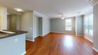 Located at 105 King Farm Blvd in Rockville, MD, this single-floor residence at King Farm offers a thoughtfully designed layout with a blend of comfort and functionality. The open-concept living and dining area features rich hardwood flooring and is bathed in natural light from large windows, complemented by a ceiling fan for year-round comfort. Crown molding adds a refined architectural touch to the living space.

The kitchen is well-equipped with warm maple cabinetry, dark granite-style countertops, a stainless steel sink, and black appliances including a gas range and over-the-range microwave. A pass-through counter connects the kitchen to the living area, creating an open and social atmosphere.

The bedrooms are carpeted in neutral tones and feature generous windows that invite abundant natural light and views of the surrounding greenery. Each room offers a calm, comfortable retreat with clean, neutral-toned walls.

The residence includes two full bathrooms, each featuring a tub-shower combination, wood-toned vanity cabinetry, and tile flooring. The layout, as seen in the floorplan overview, is efficiently organized to maximize flow between living, sleeping, and utility spaces, making this a practical and inviting home in the heart of Rockville.