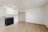 Located at 1330 Mac Arthur Dr in Carrollton, TX, this single-floor, 2-bedroom, 2-bathroom home offers a thoughtfully organized layout with a clean, neutral aesthetic throughout. The living room serves as the heart of the home, anchored by a tile-surround fireplace with a wood mantle and finished with light wood-look flooring that extends through the main living areas. A sliding glass door with vertical blinds and an adjacent window fill the space with natural light. The kitchen features white cabinetry, granite-look countertops, stainless steel appliances including a refrigerator and microwave, and a breakfast bar that opens to the dining area — all tied together by the same warm wood-look flooring. Both bedrooms are carpeted and equipped with ceiling fans, and each benefits from natural light through slatted blinds. The primary bedroom is generously sized with its own closet, while the second bedroom also includes dedicated closet storage. The bathrooms are clean and functional with white vanities. With four closets total, storage is ample throughout. A dedicated laundry area adds everyday convenience, rounding out this well-appointed home.