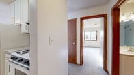 Located at 3612 Lynn Ave in St. Louis Park, MN, this single-floor unit offers a practical and well-organized layout across a compact footprint. The living area features neutral-toned carpet, white walls, and baseboard heating, creating a clean and functional space. A ceiling-mounted light fixture illuminates the room, while a window unit provides supplemental climate control. Natural light filters in through blinds-covered windows, offering views of the surrounding neighborhood.

The kitchen is efficiently designed with white cabinetry providing ample overhead storage, a gas range with oven, and tile flooring that transitions cleanly from the carpeted living space. An under-cabinet range hood adds practical ventilation to the cooking area.

A dedicated closet area with a full-width hanging rod offers convenient built-in storage, framed by a warm red accent wall that adds a touch of color to the otherwise neutral palette.

The bathroom is finished with light tile flooring, a white vanity featuring a clean countertop and brushed nickel hardware, a combined tub and shower, and white walls throughout — maintaining a bright, crisp appearance. Rich wood-toned door frames provide a warm contrast to the light interior finishes.

Overall, this unit presents a straightforward, functional layout suited for efficient everyday living.