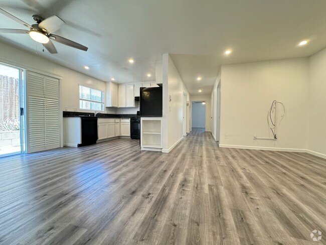 Large living room with recessed lighting, plantation shutters opening to private garden patio. Upgra - 1757 17th St