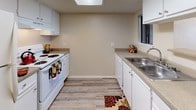 This single-floor residence offers a thoughtfully designed layout with a variety of comfortable living spaces. The open living area greets residents with light wood-style flooring, a ceiling fan, and built-in shelving that adds both character and practicality. A sliding glass door leads to an outdoor patio, allowing natural light to fill the room and providing a seamless connection to the exterior. A dedicated nook with built-in shelving adds a functional accent to the living space.

The kitchen is efficiently laid out with white cabinetry, laminate countertops, a double-basin stainless steel sink, white appliances including a range and dishwasher, and a skylight that brightens the space naturally. Wood-style flooring continues throughout, lending a clean, cohesive feel.

The bedrooms are carpeted for comfort, each offering generous floor space. One bedroom features a sliding closet and direct access to a bathroom, while another includes a window with outdoor views, filling the room with natural light. Closet storage is well-represented throughout.

The bathrooms are finished with white vanity cabinetry, countertops, large mirrors, warm overhead lighting, and wood-style flooring. Together, the spaces create a functional and comfortable living environment with consistent, neutral tones throughout.