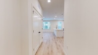 This well-appointed single-story home in Round Rock, Texas offers a clean, contemporary aesthetic throughout its three bedrooms and two bathrooms. Light-toned wood plank flooring flows seamlessly across the entire residence, creating a bright and cohesive feel.

The open-concept kitchen and living area serves as the heart of the home. The kitchen features a central island with a built-in sink, crisp white flat-panel cabinetry with under-cabinet lighting, a marble-look tile backsplash, white quartz countertops, and a full suite of stainless steel Whirlpool appliances including a slide-in range, built-in microwave, and refrigerator. Recessed lighting illuminates the space, complemented by multiple windows that invite abundant natural light.

The spacious living area extends from the kitchen and includes a glass-panel door and multiple windows offering outdoor views. Each bedroom is finished in the same light, neutral palette with ceiling fans and ample natural light. The primary bedroom includes a dedicated walk-in closet with a full-width hanging rod. The bathrooms maintain the home's modern design with white vanities and matte black hardware accents — a detail echoed throughout the doors and fixtures across the entire residence.