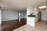 Located at 1467 Rexford Dr, Unit 302 in Los Angeles, CA, this single-floor residence offers a clean, bright layout with thoughtfully designed spaces throughout. A tiled entryway hallway provides a welcoming transition into the home, opening directly to the kitchen area.

The galley-style kitchen is well-equipped, featuring white cabinetry, granite countertops with a striking stone-patterned backsplash, stainless steel appliances including a refrigerator and wall oven, and a ceiling fan overhead. Light tile flooring runs throughout the kitchen and entry areas.

The open living and dining area is anchored by warm hardwood flooring and is bathed in natural light through a large wall of sliding glass doors that lead to a balcony with views of the surrounding neighborhood. Vertical blinds offer privacy when desired.

The bedrooms are carpeted in neutral tones and feature ample natural light from windows with vertical blinds. The primary bedroom suite includes an en-suite bathroom with a dual-sink granite vanity, well-lit mirrors, and walk-in closet access. A second bathroom features a tub-shower combination with frosted glass sliding doors, a granite vanity, and tile flooring. Throughout the unit, white walls and textured ceilings contribute to a clean, airy ambiance.