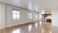 Located at 4514 Lyons Avenue in Houston, TX, this two-bedroom, one-bathroom home offers a well-designed single-floor layout with a clean, modern aesthetic throughout. The open-concept living and dining area is a standout feature, boasting elevated ceilings with exposed architectural details, gleaming wood-look flooring, and multiple large windows that flood the space with abundant natural light. The kitchen is thoughtfully equipped with rich, gray-toned cabinetry, light quartz-style countertops, and a full suite of stainless steel appliances including a refrigerator, range, microwave, and dishwasher. Both bedrooms are comfortable and well-lit, each featuring the same warm wood-look flooring and natural light from well-placed windows. A louvered closet door in the primary bedroom adds a classic touch, while two dedicated closets throughout the unit provide ample storage. The bathroom is finished with wood-look flooring, a dark-cabinetry vanity with a single sink, and a tiled tub-shower combination. A dedicated laundry area and a hallway connecting all rooms round out the functional layout of this well-appointed Houston home.