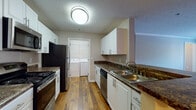 Located at 100 Preston Woods Trail in Sandy Springs, GA, this single-floor, 3-bedroom, 2-bathroom residence offers a well-organized and functional layout. The galley-style kitchen is a standout feature, outfitted with white cabinetry, dark granite-style countertops, stainless steel appliances including a refrigerator, electric range, microwave, and dishwasher, along with a double-basin sink. Warm hardwood flooring runs throughout the kitchen and connects directly to a dedicated in-unit laundry room equipped with a full-size washer and dryer. The living area is carpeted and benefits from natural light streaming through large windows, with a glass-paned door providing additional brightness. The bedrooms are generously sized, each featuring soft carpet, neutral-toned walls, and windows that bring in natural light. Both bathrooms are finished with white cabinetry, dark granite-style countertops, large mirrors, and soaking tubs with tiled surrounds. One bathroom features elegant pendant-style vanity lighting. Textured ceilings with crown molding details and consistent neutral tones throughout lend the space a cohesive, move-in-ready feel.
