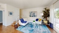 Located in Woodland Hills, CA, this two-story, 2-bedroom, 3-bathroom home is thoughtfully laid out across two equally sized floors. The main level features an open-concept living and dining area bathed in natural light, with hardwood flooring, crown molding, and access to a balcony overlooking mature palm trees, manicured landscaping, and a community sports court. The dining area is framed by large windows and sheer curtains, creating an airy, sunlit atmosphere. The kitchen is efficiently designed with white shaker cabinetry, stainless steel appliances including a gas range, microwave, and refrigerator, a double sink, subway tile backsplash, and a tray ceiling detail that adds architectural interest. A dedicated laundry area with full-size washer and dryer adds everyday convenience. Upstairs, the primary bedroom is a bright retreat featuring soaring ceilings, an arched window, multiple large windows with garden views, and a bold accent wall. It connects to a well-appointed en-suite bathroom with an extended vanity, dark countertops, and a walk-in closet with dual hanging rods. The second bedroom offers additional flexibility, while two additional bathrooms serve the home. Carpet flooring and crown molding carry throughout the upper level, adding warmth and refinement.
