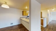 Located at 2808 S Assembly Rd in Spokane, WA, this single-floor unit offers a well-organized layout designed for comfortable everyday living. Rich wood-look flooring runs consistently throughout the space, lending a warm and cohesive aesthetic from room to room.

The open-concept entry area flows directly into the main living space, with clear sightlines toward the kitchen. The kitchen is efficiently designed with warm oak cabinetry, a mosaic tile backsplash, light countertops, and a peninsula that provides additional prep space and separates the kitchen from the living area. White appliances — including a refrigerator, electric range, and over-the-range microwave — are all included. A stainless steel sink is positioned along the peninsula for added convenience.

The bedrooms are bright and well-proportioned, each benefiting from large windows that frame views of the surrounding landscape and allow generous natural light to fill the rooms. Baseboard heating units are present in the bedrooms. A utility closet houses the water heater, providing dedicated storage for mechanical components.

The bathroom is clean and functional, featuring a wood-framed vanity mirror, oak cabinetry, mosaic tile accents, and wood-look flooring that continues from the rest of the unit. Overall, this space presents a practical and inviting environment in a convenient Spokane location.