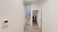 Located at 44 Courtlandt Street in New Brunswick, NJ, this well-appointed two-story unit offers three bedrooms and one bathroom across two thoughtfully laid-out floors. Light-toned luxury vinyl plank flooring flows throughout, complementing the clean, neutral palette that lends a bright and airy feel to every room.

The kitchen is a standout feature, showcasing white shaker-style cabinetry, granite countertops, a peninsula with a built-in sink, a geometric tile backsplash, and a full suite of stainless steel appliances. The open layout connects seamlessly to the rest of the main floor.

The bedrooms are generously sized, with the spacious primary bedroom offering ample room to furnish comfortably. Bedrooms feature large windows that invite abundant natural light and views of the surrounding neighborhood, along with closets providing solid storage. The primary bedroom includes a ceiling fan for added comfort.

The bathroom is finished with elegant marble-style tile surrounding a walk-in shower with brushed nickel fixtures. A dedicated laundry room houses a stacked washer/dryer unit and water heater for added convenience.

The main staircase with a warm wood handrail connects the two floors, and hallways provide smooth circulation throughout. This move-in-ready unit combines modern updates with practical functionality.