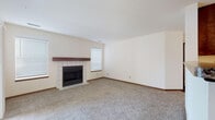 Located at 6691 S Whitnall Edge Rd in Franklin, Wisconsin, this single-floor home offers a practical and comfortable layout with well-maintained finishes throughout. The living room serves as a central gathering space, featuring plush neutral carpeting, cream-toned walls, and a wood-burning fireplace framed by white tile surround and a rich wood mantel. Multiple windows fitted with blinds allow natural light to fill the room, creating a bright and welcoming atmosphere.

The kitchen is equipped with dark espresso cabinetry, granite-style countertops, and stainless steel appliances including a range, over-the-range microwave, and refrigerator. Wood-look vinyl flooring runs through the kitchen, adding warmth and durability to the space. A peninsula counter provides additional workspace and separates the kitchen from the adjoining areas.

The entryway features the same wood-look flooring, a closet for storage, and a windowed front door that introduces natural light upon entry. A secondary room with carpet and a sliding glass door offers access to the outdoors and additional flexibility in use. The bathroom is appointed with dark wood vanity cabinetry, a light countertop, and wood-look flooring, completing the cohesive aesthetic found throughout the home.