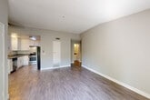 Located at 655 Enterprise Dr in Rohnert Park, California, this single-floor, three-bedroom, one-bathroom home offers a functional and well-appointed layout. The living room is bright and open, featuring durable wood-style luxury vinyl plank flooring, neutral gray tones, and a sliding glass door that invites natural light and outdoor views. The space flows seamlessly into the combined dining room and kitchen area, which is outfitted with white shaker-style cabinetry, gray countertops, a stainless steel dishwasher and range, and a built-in sink — a clean, modern aesthetic throughout. Each of the three bedrooms is finished with plush carpet and features its own closet with built-in shelving, offering practical storage solutions. The bedrooms maintain a calm, neutral palette with natural light filtering through window treatments. The full bathroom includes a tub-shower combination with a white surround, brushed nickel fixtures, a vanity with dark countertop, and matching LVP flooring. Additional utility rooms and a dedicated laundry area round out the home's practical offerings. A textured ceiling and crisp white baseboards add a consistent finishing touch throughout the entire residence.