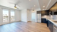 Located in San Diego's vibrant North Park neighborhood, this modern one-bedroom, one-bathroom unit offers a thoughtfully designed open-concept layout. Light-toned hardwood-style flooring flows throughout, complementing the clean white walls and recessed lighting that create a bright, cohesive atmosphere.

The combined kitchen and living area serves as the heart of the unit. The kitchen is outfitted with dark navy cabinetry on both upper and lower levels, a white tile backsplash, light countertops, and a full suite of stainless steel appliances including a refrigerator, range, microwave, and dishwasher. A ceiling fan overhead enhances comfort in the open living space, which also benefits from a large window with outdoor views.

The bedroom is a well-proportioned retreat featuring its own ceiling fan, light-filled windows, a sliding glass door that opens to a private balcony with neighborhood views, and a built-in closet with dual hanging rods for ample storage.

The bathroom is finished in a clean, minimalist style with a full soaking tub and shower combo, white subway tile surround, brushed nickel fixtures, built-in wall shelving, and wood-style flooring that ties the space together seamlessly throughout the unit.