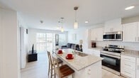 Located at 1418 Frontier Valley Dr in Austin, TX, this well-designed one-bedroom, one-bathroom unit offers a thoughtful layout across a single floor. The open-concept living and kitchen area forms the heart of the space, finished with light hardwood-style flooring and crisp white walls that maximize brightness throughout.

The kitchen is equipped with stainless steel appliances, including a range, microwave, and refrigerator, complemented by white shaker-style cabinetry and granite countertops. A central island with a built-in sink doubles as a breakfast bar with seating, making it both functional and social.

The living area flows naturally from the kitchen and is bathed in natural light from a large sliding glass door that opens to a private balcony with open outdoor views — a standout feature of the space. The bedroom is comfortably proportioned, offering two windows with outdoor views, a ceiling fan, and direct access to a spacious walk-in closet outfitted with dual hanging rods and shelving on both sides.

The bathroom features a granite-topped vanity with white cabinetry, consistent with the finishes found throughout the unit, along with a shower-tub combination. Clean, modern, and efficiently laid out, this Austin residence offers a cohesive and comfortable living experience.