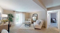 Located at 10304 Beau Jardin Dr in Saint Louis, Missouri, this single-floor residence offers a well-organized layout with a comfortable and cohesive design throughout. The spacious living room is a standout feature, showcasing neutral-toned walls, plush wall-to-wall carpeting, and a large sliding glass door that floods the room with natural light and provides views of the surrounding greenery. The open sightline from the living room connects seamlessly to the dining area, which is centered under a ceiling fan fixture and features enough space for a round dining table and chairs, creating an inviting setting for meals. The kitchen is equipped with warm wood cabinetry, a built-in microwave, electric range, and ample counter space, offering practical functionality. A dedicated office or flex room provides a quiet retreat, complete with a window for natural light and generous carpet space. The bedroom is well-proportioned with large windows dressed in sheer curtains, a ceiling fan, and soft carpeting, contributing to a restful atmosphere. The bathroom includes a full tiled tub-shower combination, tile flooring, and clean, classic finishes. A carpeted hallway with panel doors and built-in closet storage connects the private spaces, completing this thoughtfully laid-out single-level home.