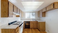 Located at 789 Springwood St3 in Corona, California, this two-floor space offers a straightforward and functional layout with a consistent design aesthetic throughout. The kitchen is well-equipped, featuring warm oak cabinetry that extends from base to upper levels, providing generous storage. Light-toned countertops complement the cabinetry, while a gas range, built-in dishwasher, and double-basin sink serve as the primary appliances. A large window fitted with vertical blinds allows natural light to brighten the kitchen, and hardwood-style flooring ties the space together. A skylight-style ceiling panel further enhances the brightness of this area.

The living area is spacious and open, with plush wall-to-wall carpeting and a large window that invites natural light. The textured ceiling and neutral white walls create a clean, understated atmosphere. The carpeted bedrooms echo this calm aesthetic, each benefiting from windows that provide natural illumination and good ventilation. The rooms offer ample open floor space suitable for a variety of furniture arrangements.

The bathroom features a wide vanity with a speckled countertop, an integrated sink, and a large wall mirror accented by a row of globe lights. A full tub-shower combination with white tile surround completes the space, all set on hardwood-style flooring for a cohesive finish.