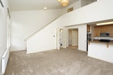 Located at 1804 Mission St in Santa Cruz, California, this two-story home offers a thoughtfully arranged layout across two levels connected by a staircase. The main living area is bright and spacious, with plush carpeting, soaring vaulted ceilings, and a sliding glass door that opens to a private deck overlooking lush greenery — an inviting indoor-outdoor connection that brings natural light deep into the interior. A wall-mounted radiator provides supplemental heating to this area.

The kitchen is well-appointed with warm honey-toned wood cabinetry, granite-style countertops, and a full suite of stainless steel appliances including a range, built-in microwave, and dishwasher. Light flooring ties the space together cleanly.

Upstairs, the bedroom features soft carpeting, a ceiling fan with light fixture, a built-in closet with sliding doors offering ample storage, and an additional louvered door for a secondary closet or utility space. The staircase landing opens into a generously sized carpeted area that could serve as additional living or flex space.

Two full bathrooms serve the home — one featuring a granite-topped vanity with accessibility grab bars, and a second with a glass-enclosed tub/shower combination, also equipped with grab bars, providing both comfort and accessibility throughout.