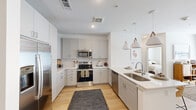 Located on Dionda Lane in Austin, TX, this well-designed one-bedroom, one-bathroom residence offers a thoughtfully laid-out single-floor plan with a clean, contemporary aesthetic throughout. Light wood-style flooring flows seamlessly across the main living areas, complementing the bright, neutral color palette.

The kitchen is a standout feature, equipped with stainless steel appliances including a French door refrigerator, electric range, built-in microwave, and dishwasher. Gray shaker-style cabinetry with white quartz countertops lines the perimeter, while a peninsula with an undermount sink and pendant lighting above provides additional prep and dining space. A dedicated mudroom nook with built-in hooks and storage adds practical convenience near the entry.

The living room is filled with natural light through large windows and a glass door, and features a ceiling fan overhead. The bedroom is a comfortable, well-proportioned retreat with a ceiling fan, a natural light-filled window, and direct access to the bathroom.

The bathroom is finished with large-format tile flooring, a wide vanity with white countertop and framed mirror, and a shower-tub combination with white tile surround. A closet completes the layout, providing dedicated storage. Overall, this residence offers a modern, cohesive living experience in Austin.