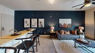 Located at 927 West Morgan St in Raleigh, NC, this single-floor residence offers a thoughtfully designed layout with a cohesive blend of modern finishes and warm, inviting interiors. The kitchen is outfitted with rich dark cabinetry, granite countertops, stainless steel appliances including a refrigerator, range, and built-in microwave, and hardwood flooring that adds warmth and character. The living area features plush carpeting, a ceiling fan, and large sliding glass doors that open onto a private balcony, filling the space with natural light and outdoor views. A separate dining area with a granite-topped bar and bold navy accent wall creates a striking yet functional space. The primary bedroom is highlighted by a deep plum accent wall, generous natural light from large windows, and ample room for a full furniture arrangement. Additional bedrooms feature their own accent walls in earthy green and neutral tones, each with large windows and carpeted floors. The bathrooms are finished with dark wood vanities, granite countertops, tile flooring, and a tub-shower combination, offering a clean and functional design throughout.