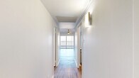 Located at 99 N Main St in the heart of downtown Memphis, Tennessee, this efficiently designed unit offers a thoughtful layout across a single floor. Wood-style plank flooring runs throughout, lending a clean, modern aesthetic to every room.

The bright, open living room is anchored by a ceiling fan and flooded with natural light from a large sliding glass door that leads directly to the private balcony. From this outdoor space, expansive panoramic views of the surrounding Memphis skyline and landscape provide a striking backdrop. The kitchen is positioned as an open pass-through with white cabinetry, stainless steel appliances, and a breakfast bar that connects seamlessly to the living area.

A clean, well-lit hallway connects the primary spaces to two closets and two bathrooms. The bathrooms feature white subway tile in the tub/shower surround, a wide vanity with a solid white countertop, gray shaker-style cabinetry, brushed nickel fixtures, and a large mirror that amplifies the sense of light. The neutral white walls throughout the unit maintain a bright and airy ambiance, making the space feel open and inviting. The efficient floor plan makes excellent use of every square foot, offering a functional and comfortable living environment in a prime downtown Memphis location.