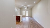 This single-floor, 2-bedroom, 3-bathroom residence offers a thoughtfully designed layout that maximizes functionality and comfort. The open-concept main living area combines the dining room, kitchen, and living room into one cohesive space. Vaulted ceilings with a ceiling fan lend an airy, spacious feel, while wood-look flooring flows consistently throughout. A sliding glass door at the rear of the living area invites natural light and provides exterior access.

The kitchen features rich, dark cherry cabinetry, granite-look countertops, black appliances including a refrigerator, range, microwave, and dishwasher, and a peninsula with pendant lighting and a secondary sink — ideal for both everyday cooking and casual dining.

The primary bedroom is a comfortable retreat with multiple closets, while the second bedroom also includes closet storage. Three well-appointed bathrooms serve the residence, each finished with matching dark wood vanities, granite-look countertops, and large mirrors. One bathroom includes a walk-in shower. Additional utility is provided by a dedicated laundry area, pantry, and five closets throughout.

A central hallway connects the private bedroom wing to the main living spaces, creating a clear and practical floor plan. Neutral wall tones and consistent wood-look flooring tie the entire residence together cohesively.